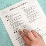 Load image into Gallery viewer, A hand erases a laminated daily garden maintenance checklist
