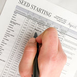 Load image into Gallery viewer, A hand fills in the Seed Starting printable chart with a black pen
